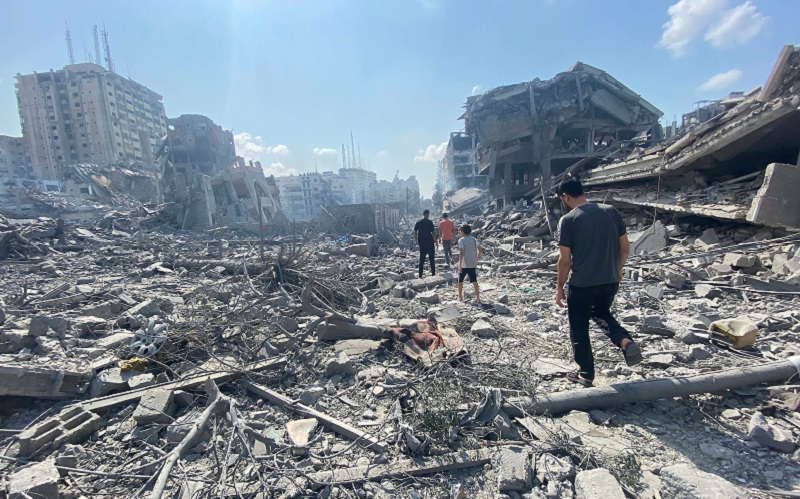 Palestinians inspect the damage following an Israeli airstrike on the El-Remal area in Gaza City on October 9.